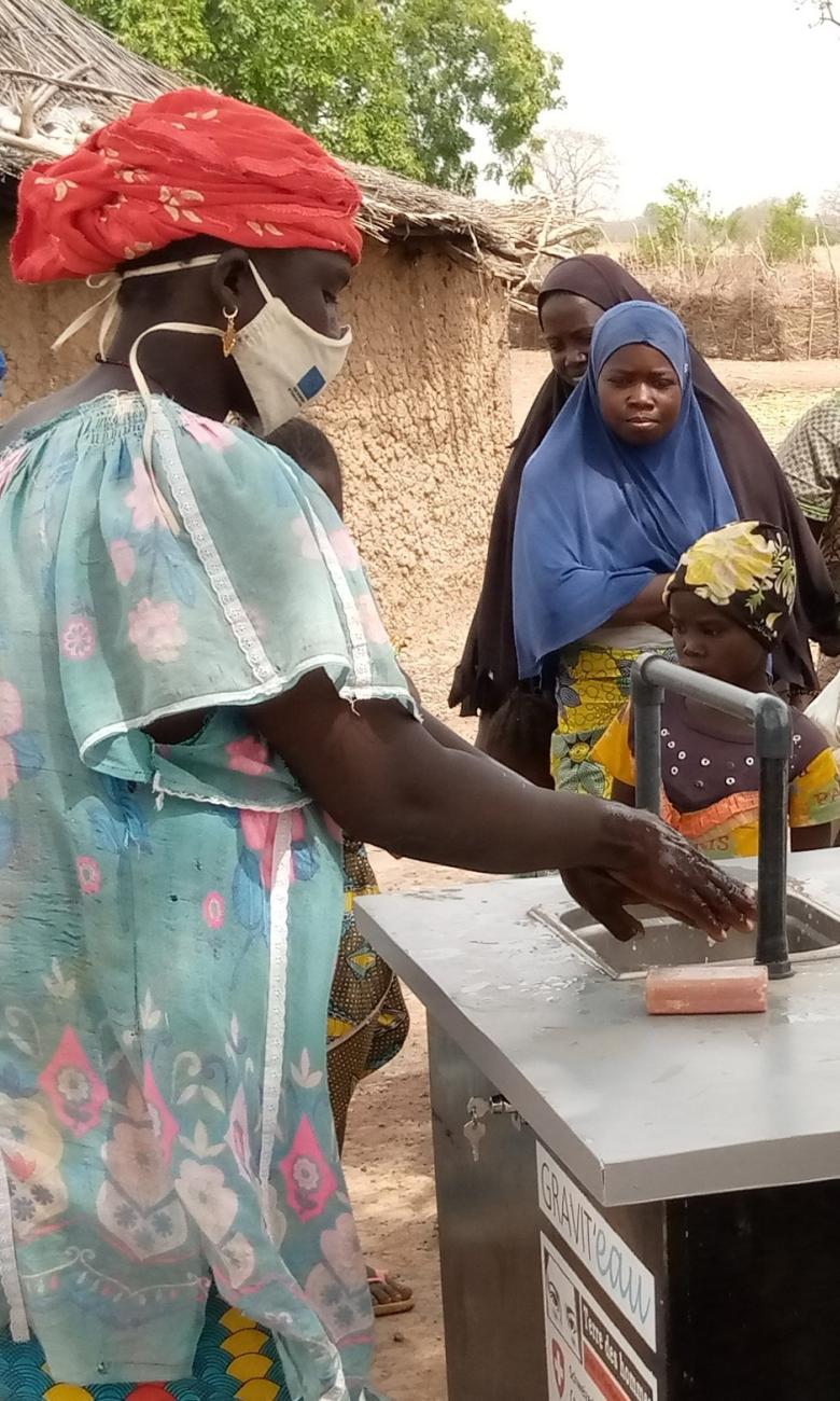 Mujeres de la zona de desplazados internos de Fangasso, en el círculo de Tominian-Ségou (Malí), utilizan el dispositivo de reciclaje de agua Gravit'eau para lavarse las manos en 2021 © Terre des hommes