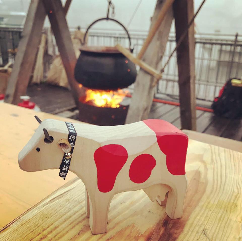 petite vache en bois près d'un chaudron