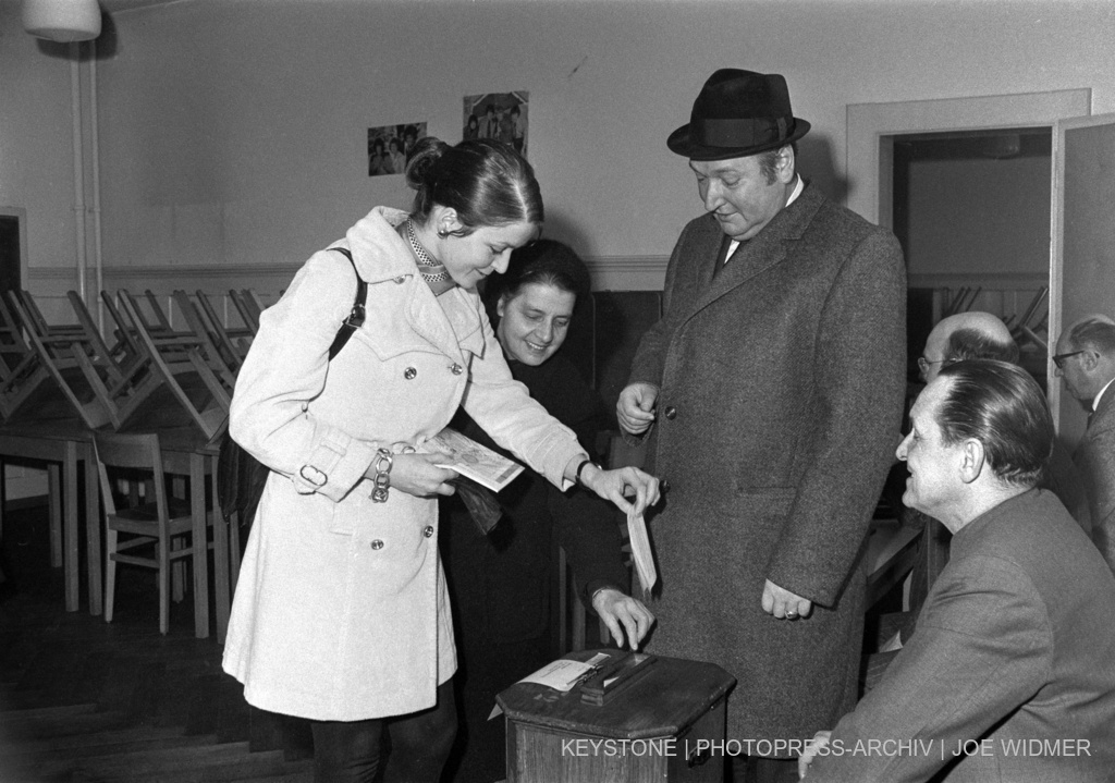 A young woman throws her ballot paper into the ballot box. 