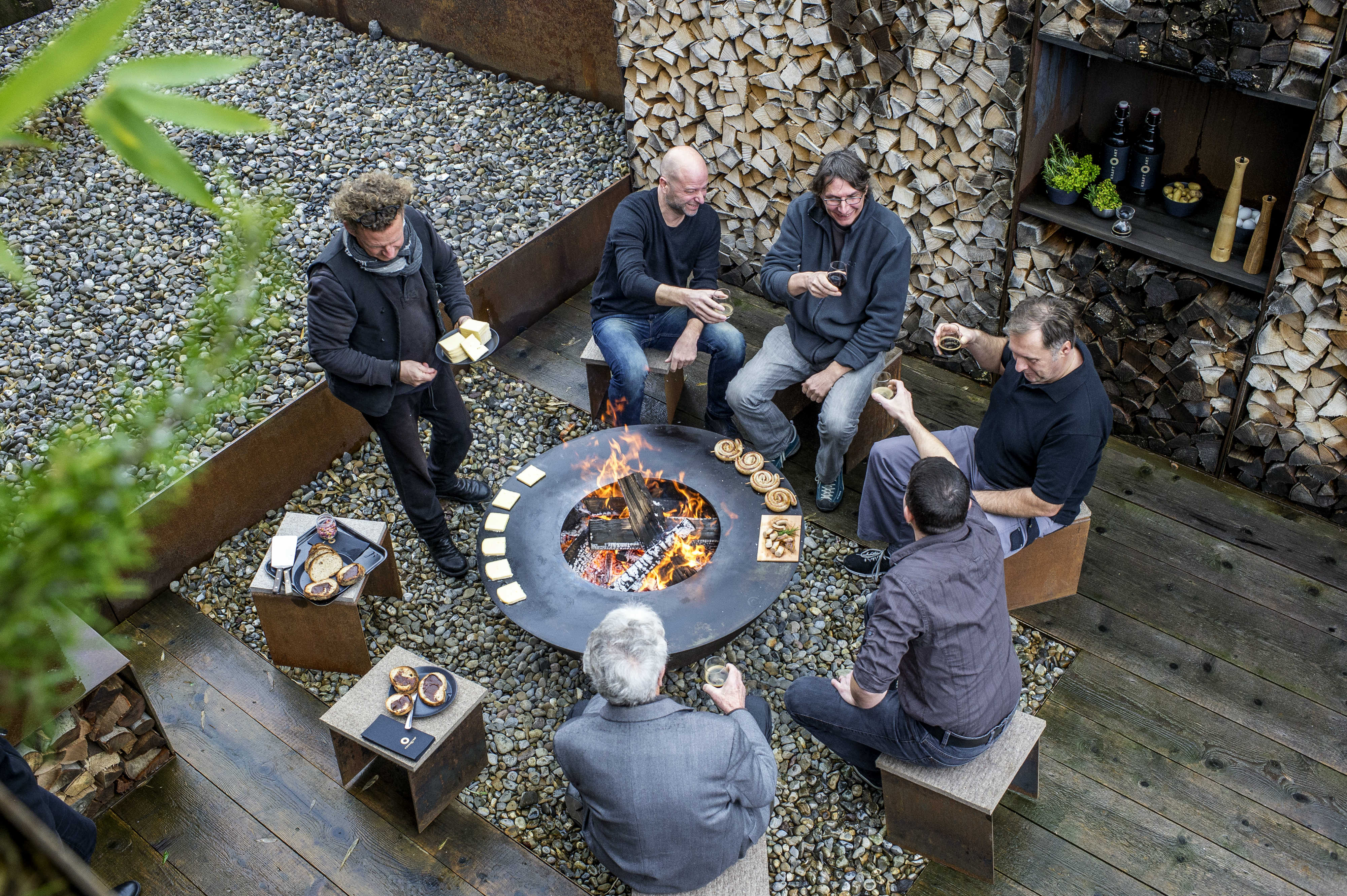 A group of people sitting around a Feuerring having a good time
