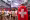 Visiteur portant un drapeau suisse regardant les compétitions olympiques sur un écran géant à la Maison Suisse.