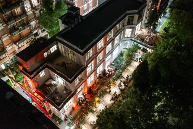 Bird's eye view of a modern building at night with bright orange lights