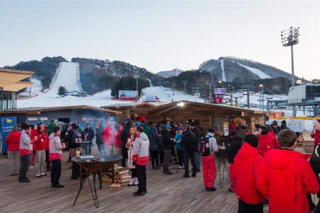 Visitors gathering at the House of Switzerland in a snowy ski resort setting.