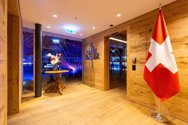 A welcoming House of Switzerland interior in Davos, featuring the Swiss flag and views towards the World Economic Forum venue.