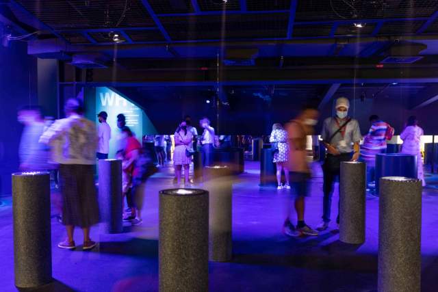 An interactive innovation exhibition inside the Swiss Pavilion, with visitors exploring illuminated installations.